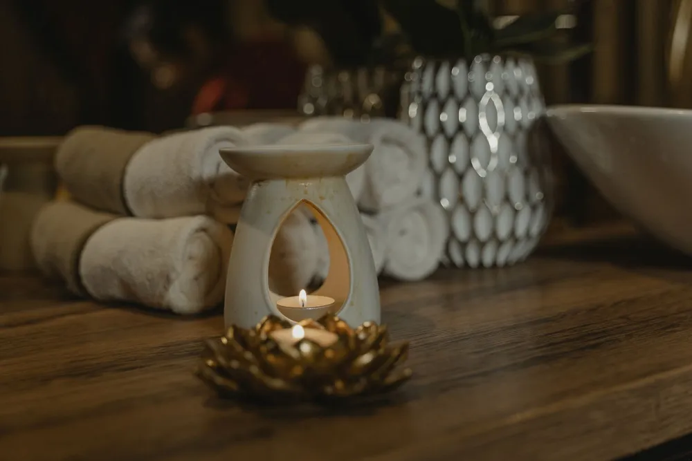 Warm candlelight beside rolled towels